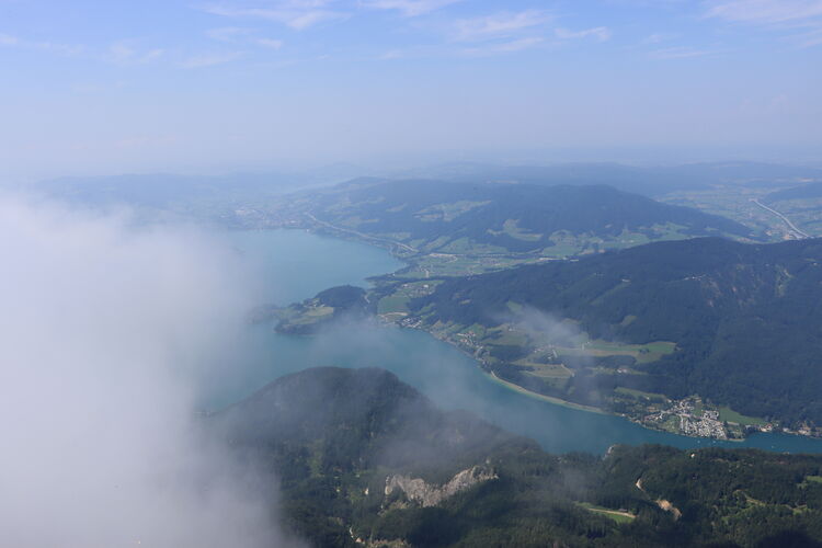 Wolkenfetzen ziehen um den Schafberg, der Mondsee liegt in der Sonne